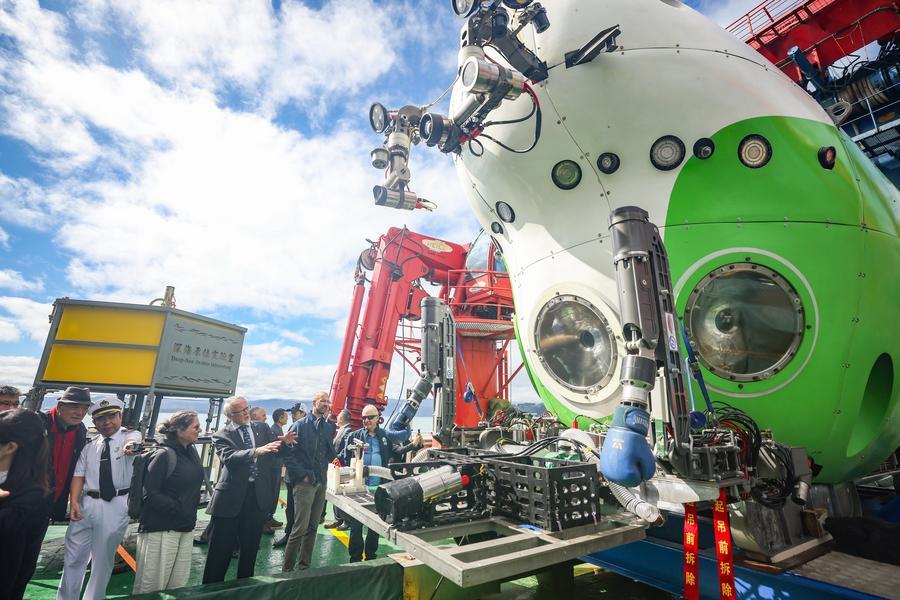 Pessoas observam o submersível tripulado de águas profundas Fendouzhe (Esforçador) a bordo do navio de pesquisa Tansuo-1 durante um dia aberto de conclusão de uma expedição conjunta de mergulho entre a China e a Nova Zelândia em Wellington, Nova Zelândia, em 21 de março de 2025. (Xinhua/Long Lei)