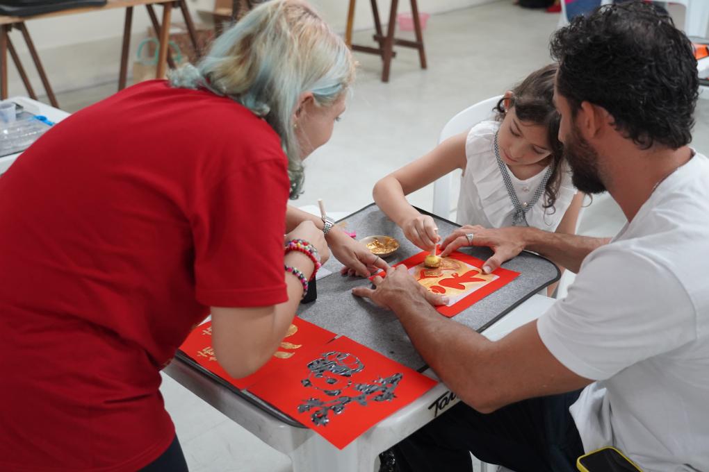 Visitantes brasileiros experimentam a técnica de esfregar (gravura em pedra) durante o V Festival da Cultura Chinesa da Paraíba, em João Pessoa, em 7 de março. (Xinhua/Zhou Yongsui)