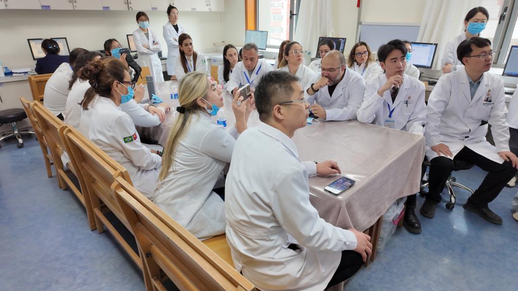 Participantes do curso de aperfeiçoamento em medicina tradicional chinesa para brasileiros analisam casos clínicos em conjunto com médicos do Hospital Afiliado da Universidade de Medicina Tradicional Chinesa de Gansu, em Lanzhou, capital da Província de Gansu, no noroeste da China, em 25 de março em 2026. (Xinhua/Duo Lei)