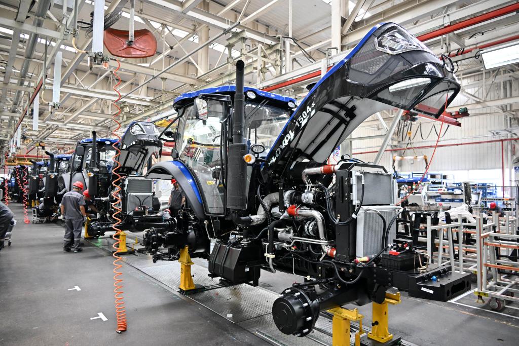 Trabalhadores montam tratores inteligentes na fábrica de tratores da Weichai Lovol Inteligent Agricultural Tecnology Co., Ltd., localizada na cidade de Weifang, na Província de Shandong, no leste da China, em 21 de agosto de 2024. (Xinhua/Li Ziheng)
