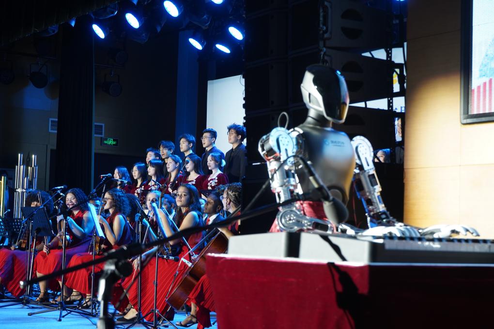 O Grupo Artístico da Universidade Renmin e a Orquestra Forte de Copacabana se apresentam com robô no salão da Universidade Renmin, em Beijing, capital da China, na noite de 14 de abril de 2026. (Xinhua/Zhu Yilin)