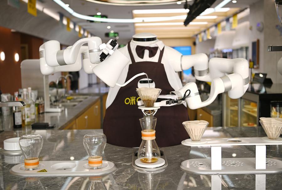 Um robô alimentado por IA prepara café em uma cafeteria na Nova Área de Xiong'an, na Província de Hebei, norte da China, em 25 de março de 2026.&nbsp;(Xinhua/Zhu Xudong)